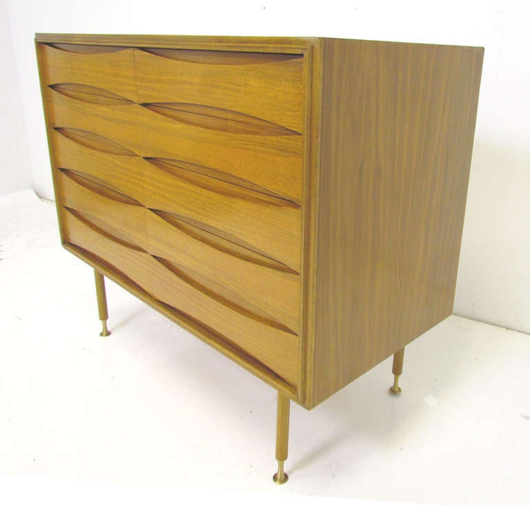 Eight drawer dresser with carved elliptical drawer fronts and spooled brass feet by Erno Fabry for Fabry Associates, ca. 1960s.  Highly figured grain, masterfully bookmatched.

Top two rows of drawers feature felt lining and dividers, and are 3