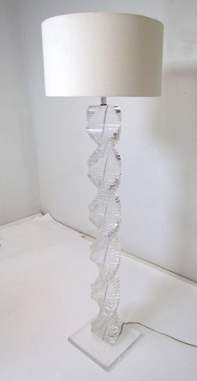 Sculptural and striking floor lamp of tightly stacked Lucite blocks, arranged in a cascading spiral.   Original Lucite finial.  Ca. 1970s, in the manner of Karl Springer.

65.5