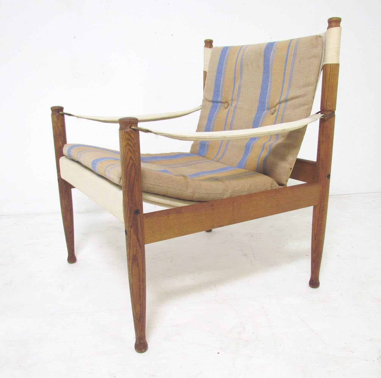 Pair of safari sling lounge chairs by Erik Wørts for Niels Eilersen, Denmark, circa 1960s. Original canvas slings, arms and seat cushions.