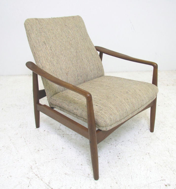 Danish open arm lounge chair with adjustable seat, designed by Soren J. Ladefoged, ca. late 1950s. The carved paddle arms are quite sculptural.  Employs a clip system permitting placement of the seat in two different positions, one more reclined