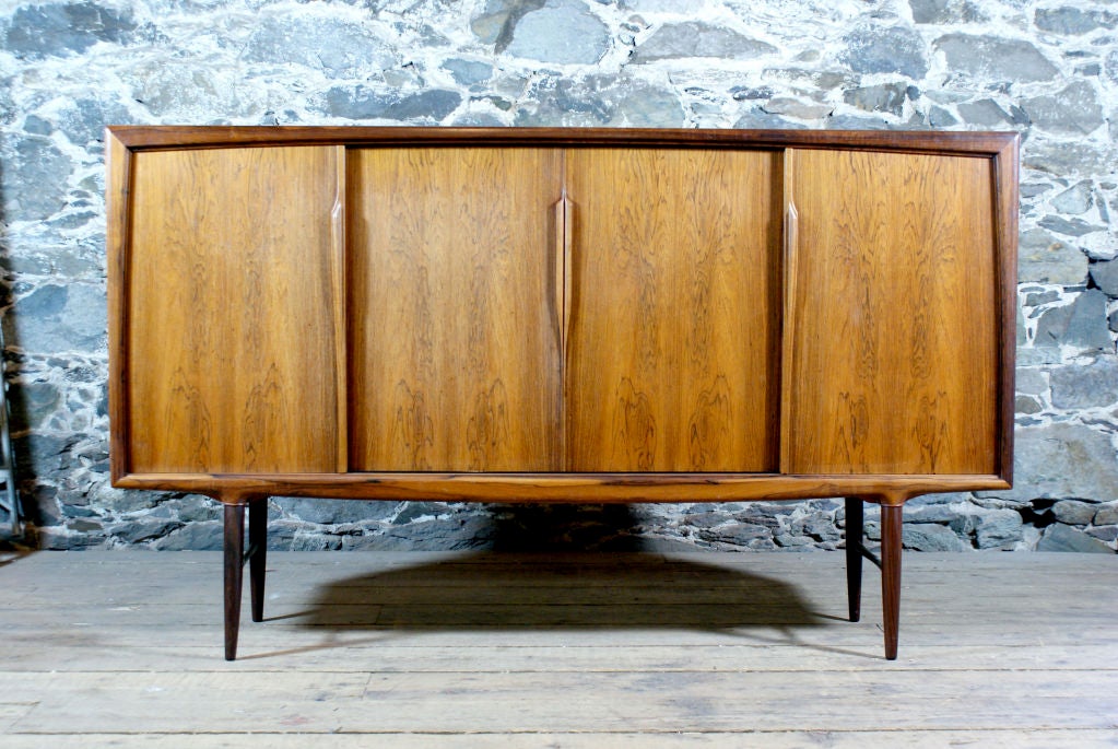 Danish Modern rosewood sideboard by Oman Junn.   Mirror backed compartment with flatware drawers, shelving for additional storage.