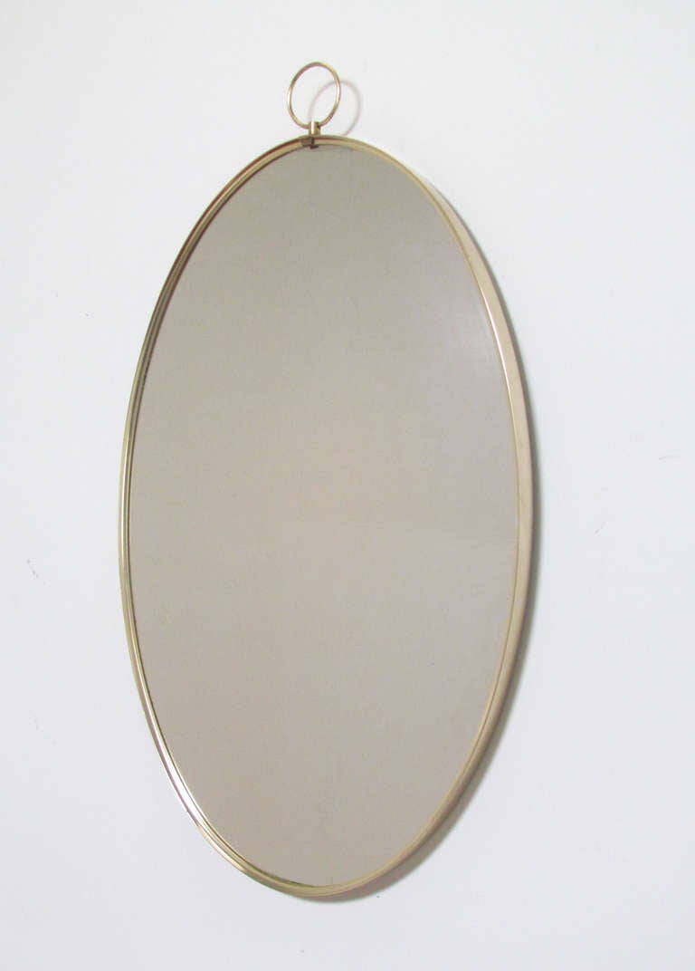 Italian brass modernist wall mirror with decorative top ring, ca.1960s.  