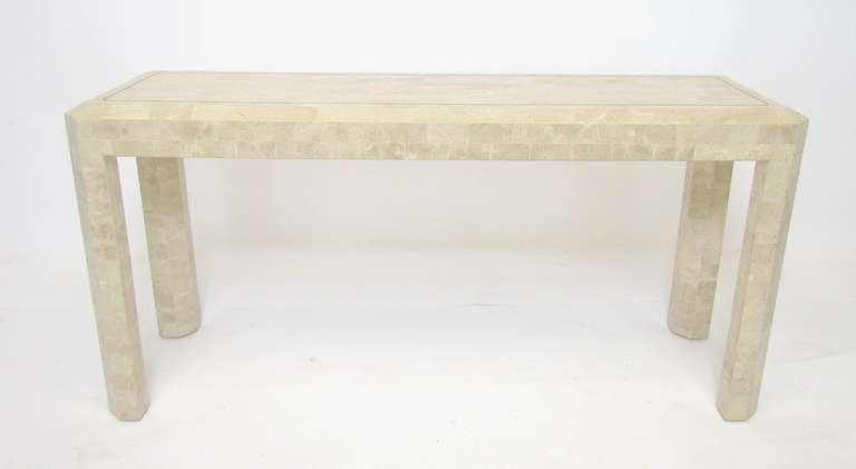 Console hallway or sofa table in tessellated fossil stone with beveled edges, and inlaid brass trim border, marked “Made in Philippines” with a Maitland Smith 