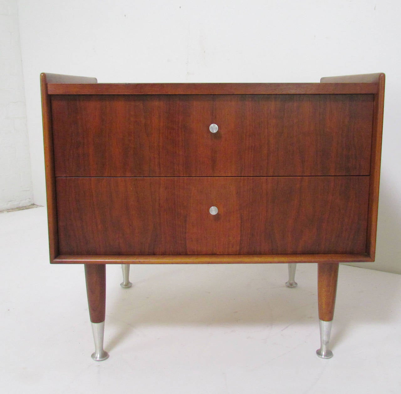 Mid-Century Modern nightstands in walnut with aluminum pulls and spun aluminum feet by Edmond Spence, Sweden, circa 1950s, in the early Danish modern style.