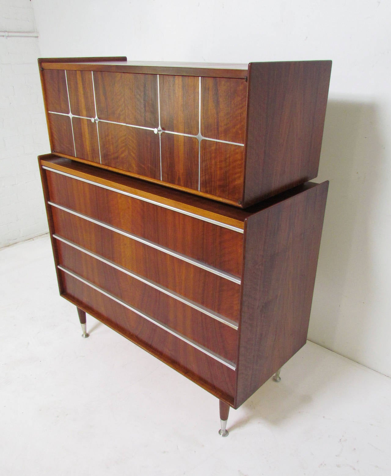 Mid-century highboy (two-piece) dresser in walnut with aluminum grid inlay and pulls, and spun aluminum feet, designed by Edmond Spence, made in Sweden, in the early Danish Modern style.

The lower cabinet measures 40