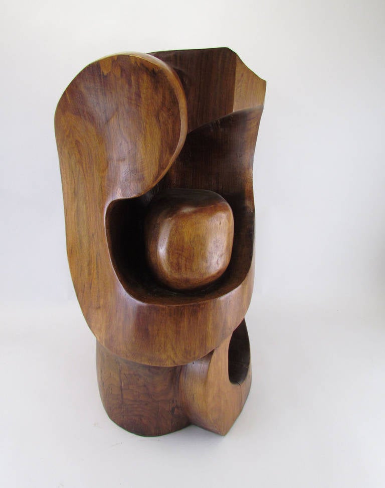 Abstract hand carved wood floor sculpture by noted sculptor Edmund Spiro.  At stool height, this piece has served for years as an occasional seating perch in a mid-century living room (note scooped depression at top).

Spiro, a WW II veteran now