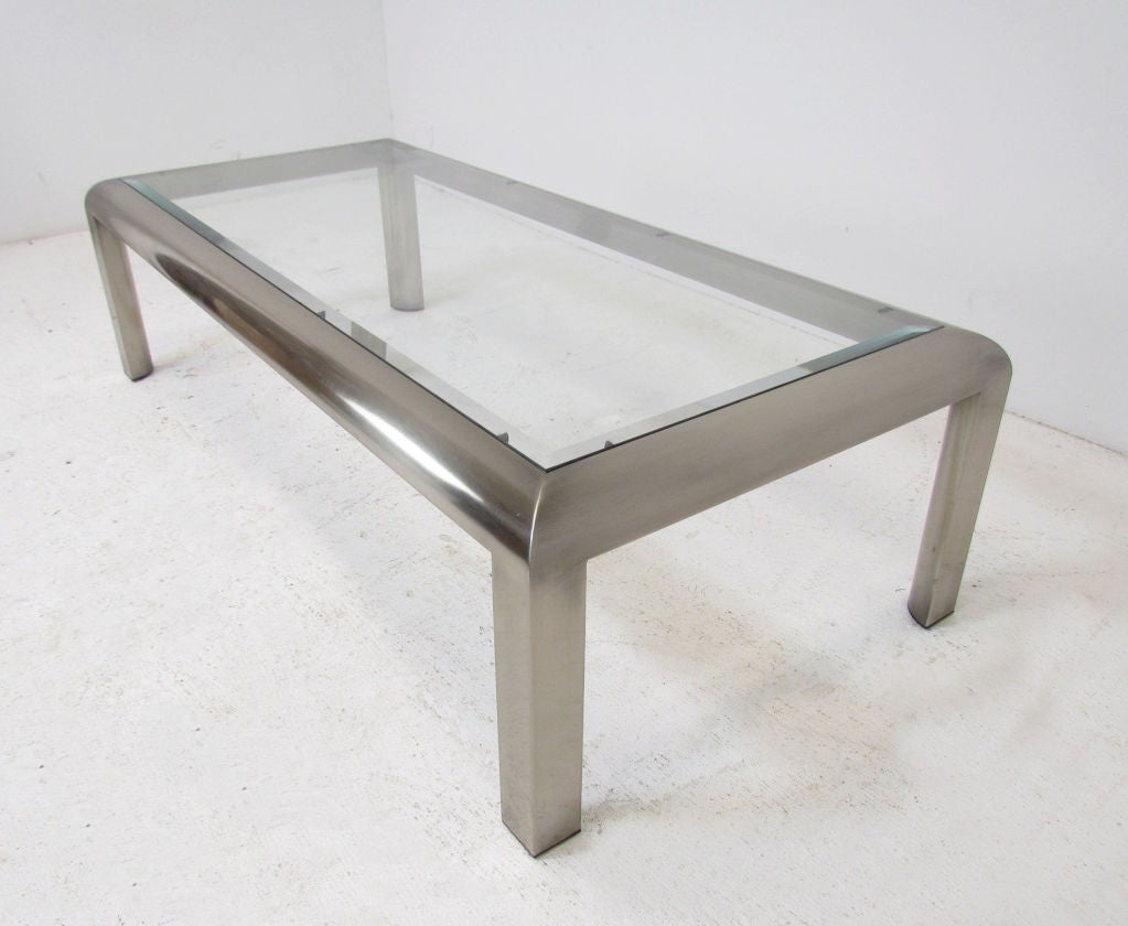 Sleek rectangular coffee table with radiused corners by Design Institute of America (DIA) in nickel finish with inset beveled glass top.  Dated 1984.