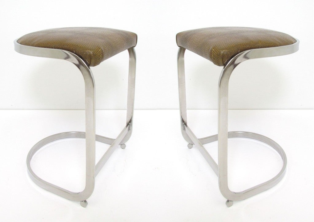 Pair of cantilever barstools  (counter stools) in flat bar chromed steel, with an art deco influence.   Seats upholstered in embossed leather.  In the manner of Milo Baughman.  Seat height of 24