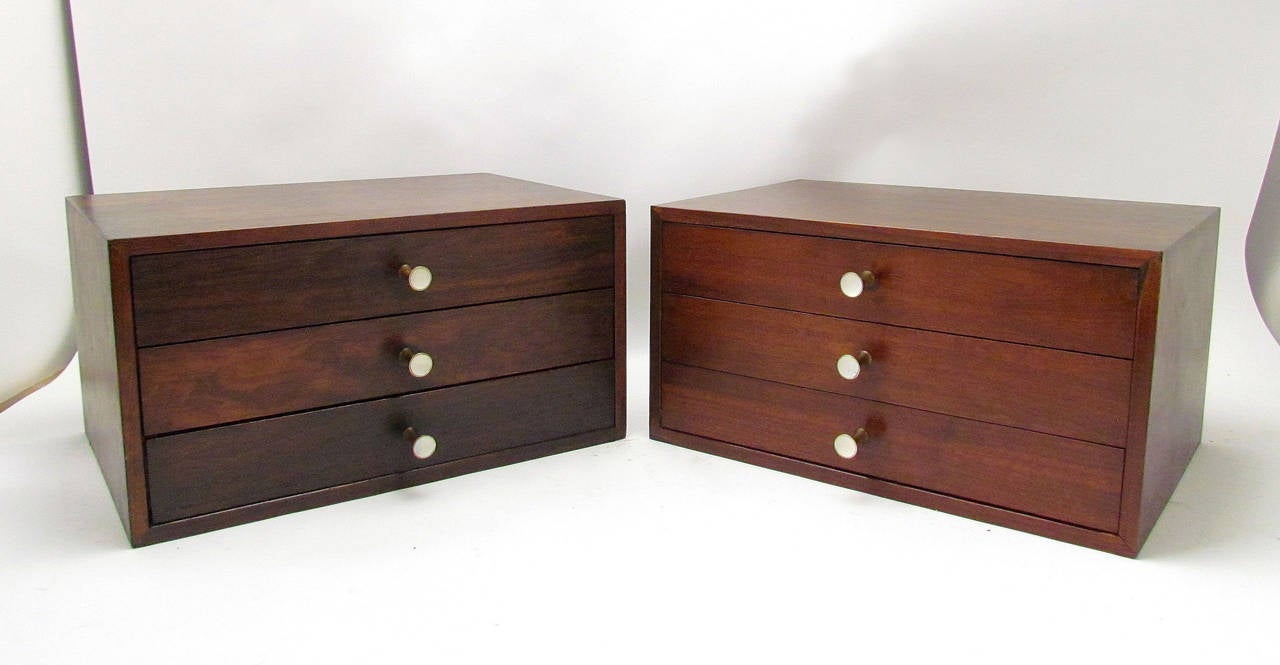 Pair of modernist Mid-Century artisan made jewelry boxes in rosewood, circa 1960s. Each with three drawers with solid brass and enameled pulls.

Ever so slight difference in size due to handmade nature. 
One measures 15 7/8