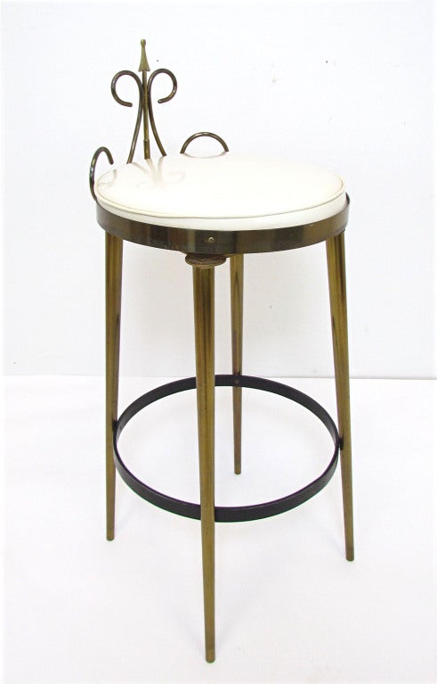 Set of three swivel bar stools in brass with crested backs and contrasting lacquered steel foot rests.   Swivel mechanism by Seng Chicago dates these to the early 1950s.  Seat cushions appear to be patent leather.