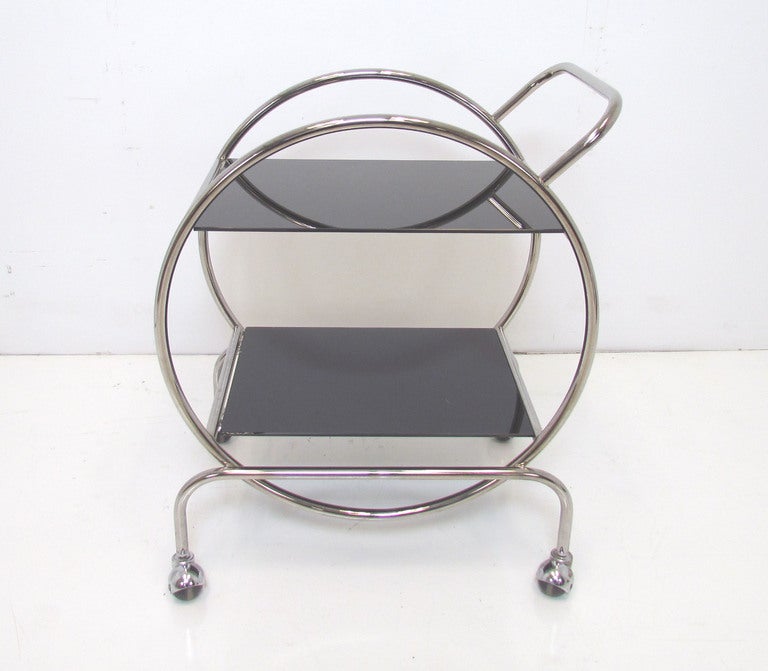 French Art Deco inspired hoop-form cocktail trolley in chromed steel with black tinted glass shelves, on multi-directional casters. Revival piece, likely dates to 1960s.  In fine vintage condition with some small, virtually undetectable pinpricks of