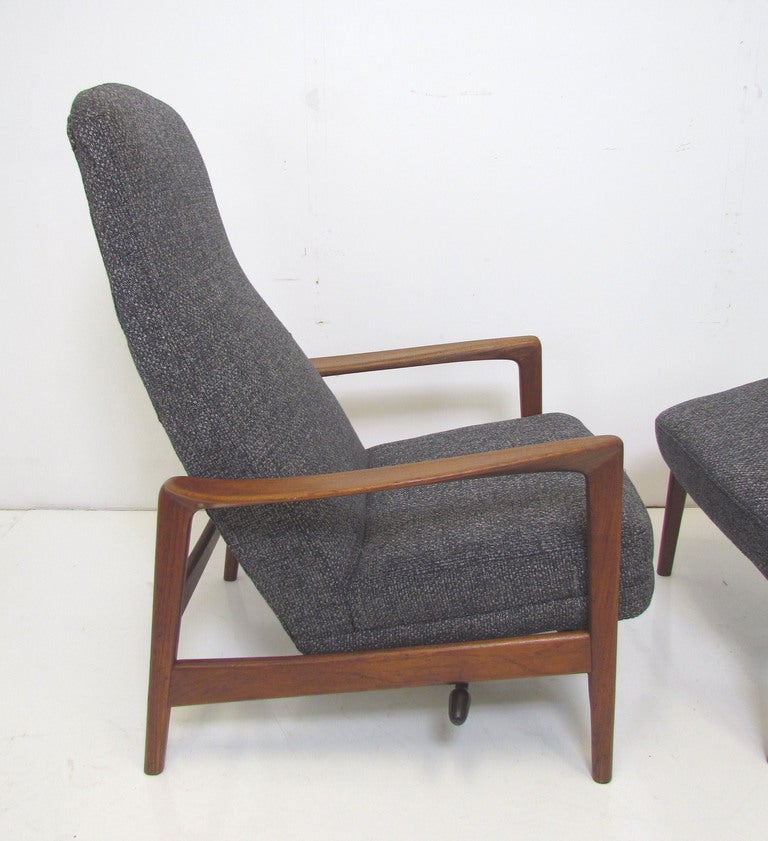 Danish Modern teak highback lounge chair with elegant carved arms, and matching ottoman, by Folke Ohlsson for Dux, Sweden, ca. early 1960s.  The chair and ottoman each feature one reclining position.   Recently reupholstered.  In upright position,