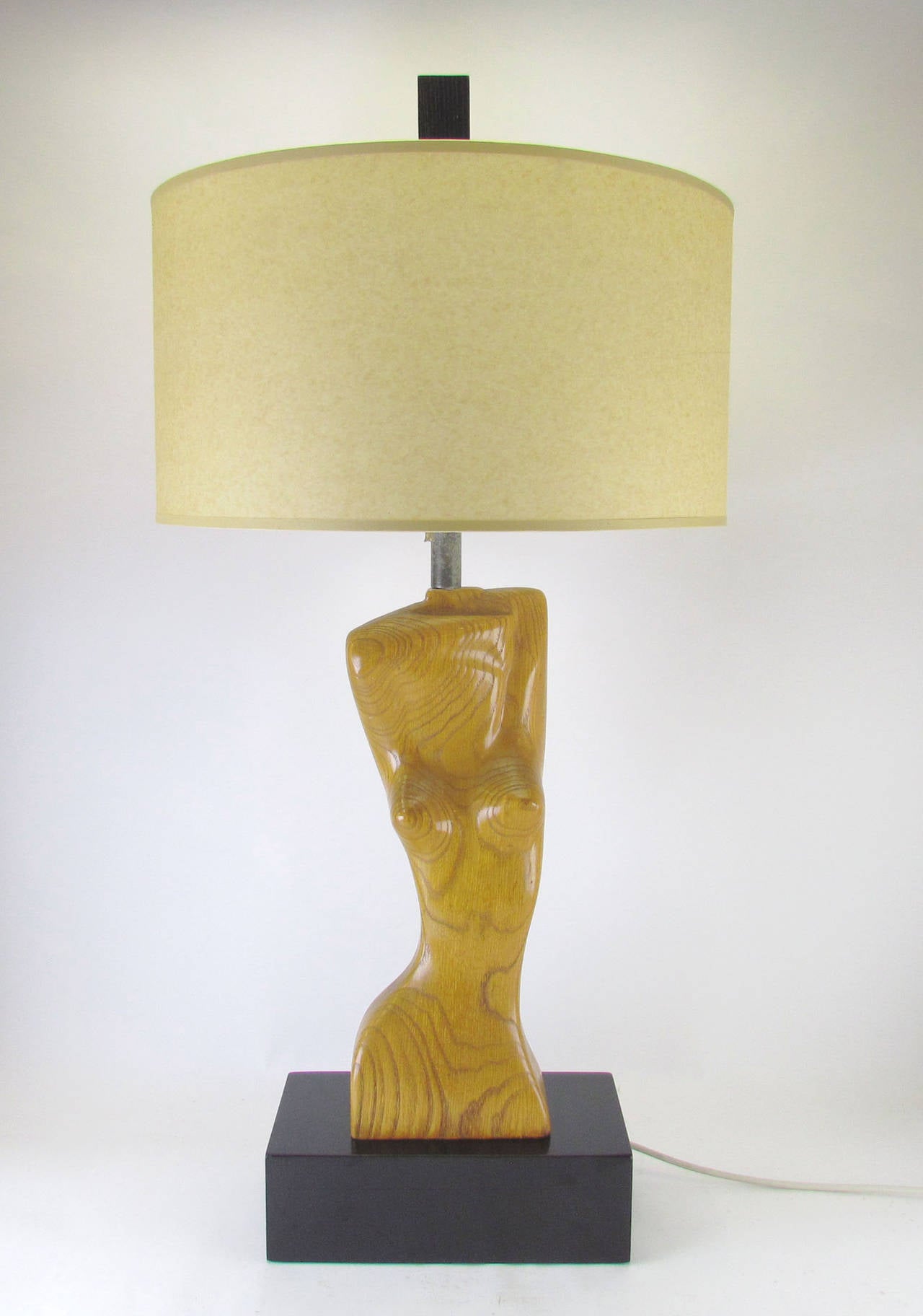 Female form torso table lamp in carved oak on a lacquered pedestal, attributed to Yasha Heifetz, circa 1950s.

Measures: 38