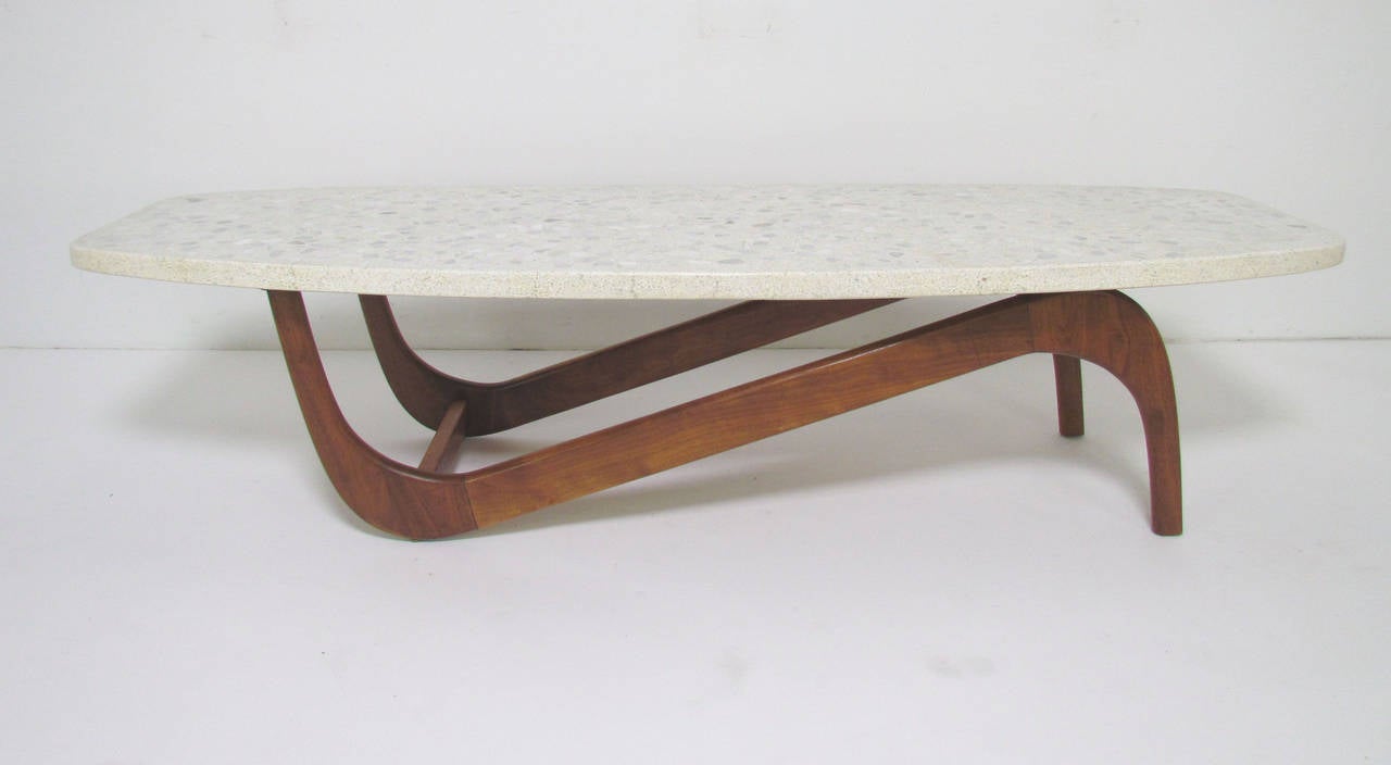 Unusual form coffee table with sculptural carved walnut base and a terrazzo stone top, unsigned, but most likely by Adrian Pearsall for Craft Associates of Wilkes Barre, PA. 

Perhaps more than any other American manufacturer, Craft Associates