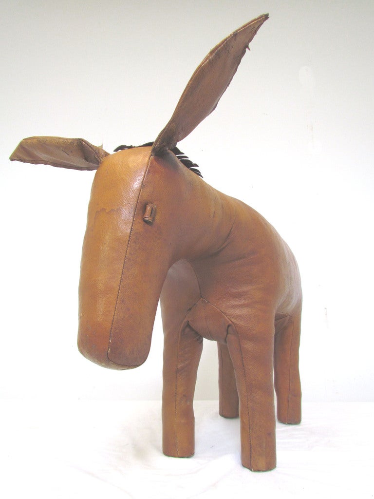 Stuffed leather donkey footstool or toy designed by Dimitri Omersa for Abercrombie and Fitch, ca. 1960s.

In very good vintage condition, with some distress and toning to leather as is typical to these  items.  Sturdy legs.