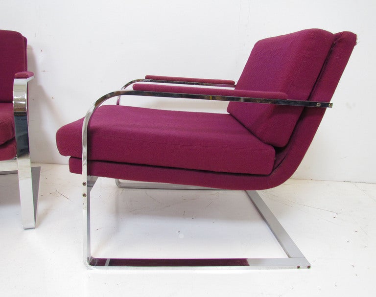 Pair of cantilevered chrome lounge arm chairs in flat bar reflective chromed steel, ca. 1970s, in the manner of Milo Baughman for Thayer Coggin.

Frames are in fine vintage condition with minimal wear.  A few tears to the original upholstery.