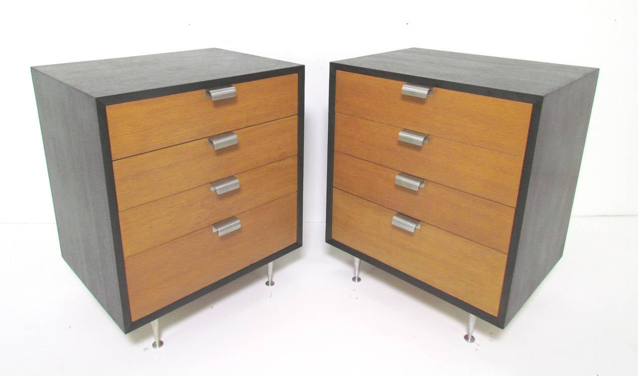 Pair of George Nelson for Herman Miller primavera chests of drawers, circa 1950s, also are a great size to serve as nightstands. Ebonized cases with contrasting mahogany fronts, and cast aluminum pulls. Replacement cast aluminum legs.