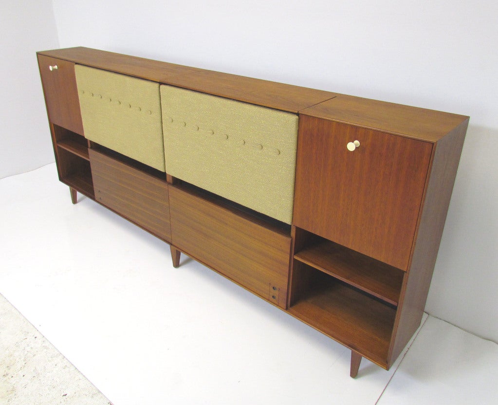 Headboard by George Nelson for Herman Miller with built-in nightstands, ca. 1960s.  Nightstands feature drop down end tables with storage cubbies and angled swing-arm reading lamps.  Adjustable headrests.   Includes additional storage area for