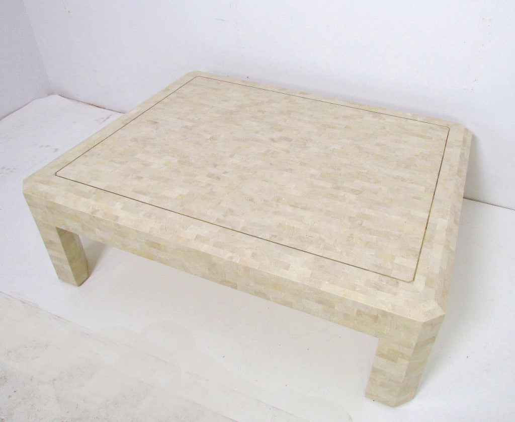 Large 50.5” x 40.5” coffee table in tessellated fossil stone with beveled edges, and inlaid brass trim border, marked “Made in Philippines” with stock number, undoubtedly by Maitland Smith.