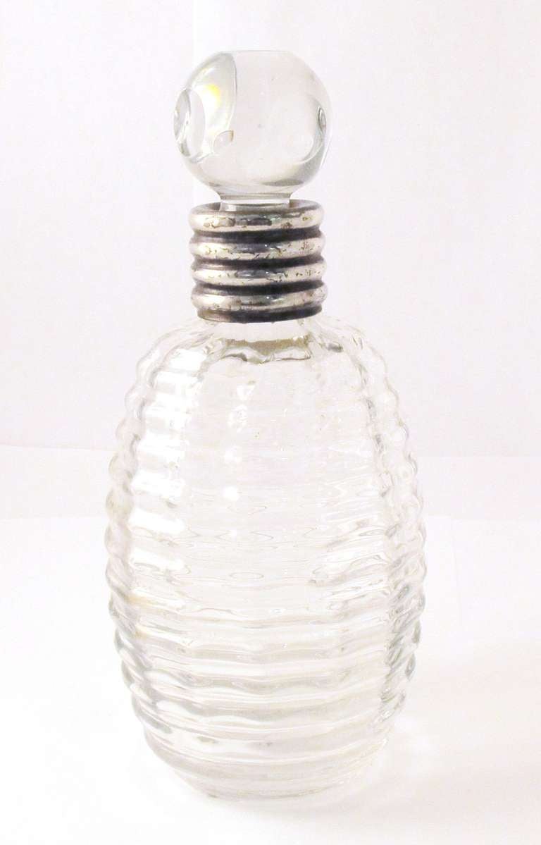 Art Deco glass decanter with ribbing detail, sterling silver rim, French c. 1930.

*For decorative purposes only.
*Not available for sale or to ship in the state of California.