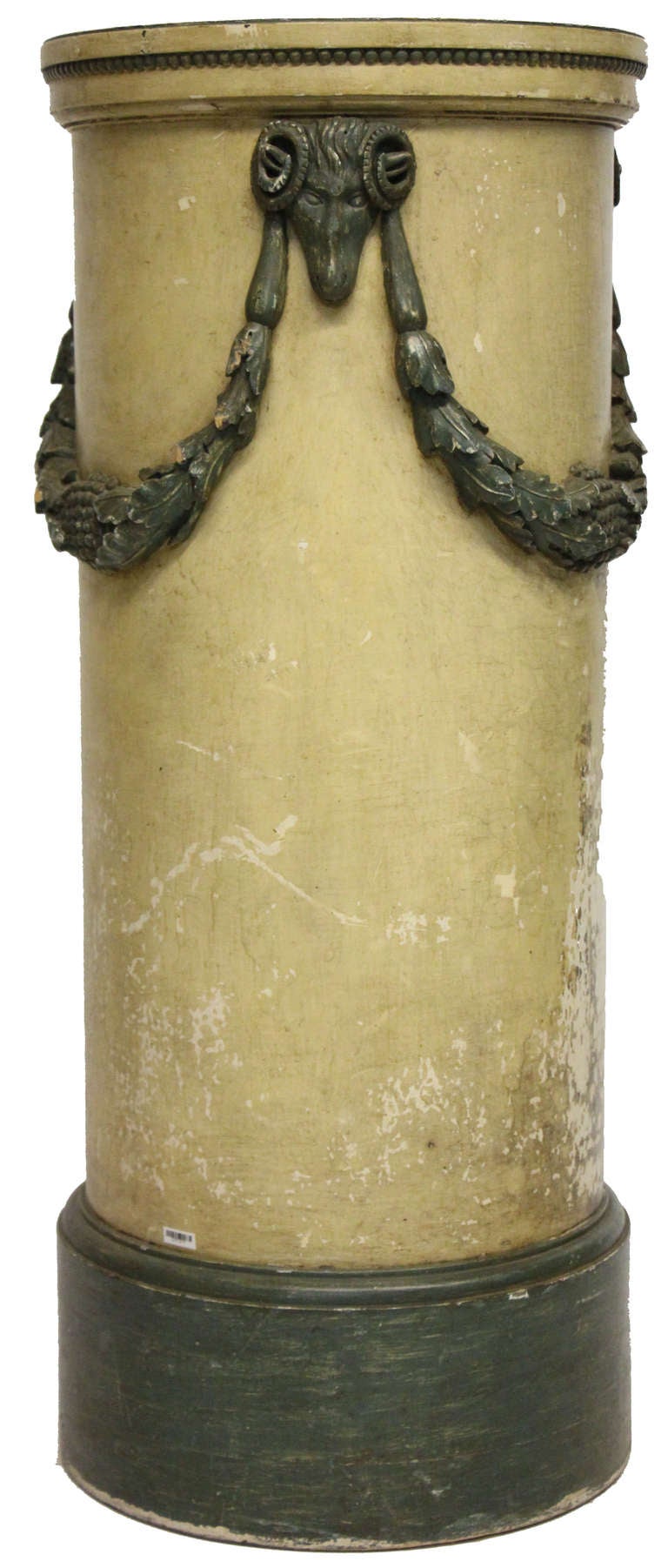 French wooden column detailed with acanthus leaf swags and a hand-carved ram head on either side.