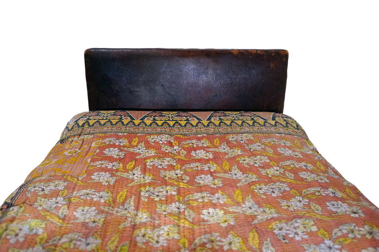19th century daybed with aged leather and bronze rivets. Cushion was recently made and comfortable while accentuating the Moroccan vibe. Sturdy legs and structure but one side has a separation in the leather at the seam. Could be easily fixed or