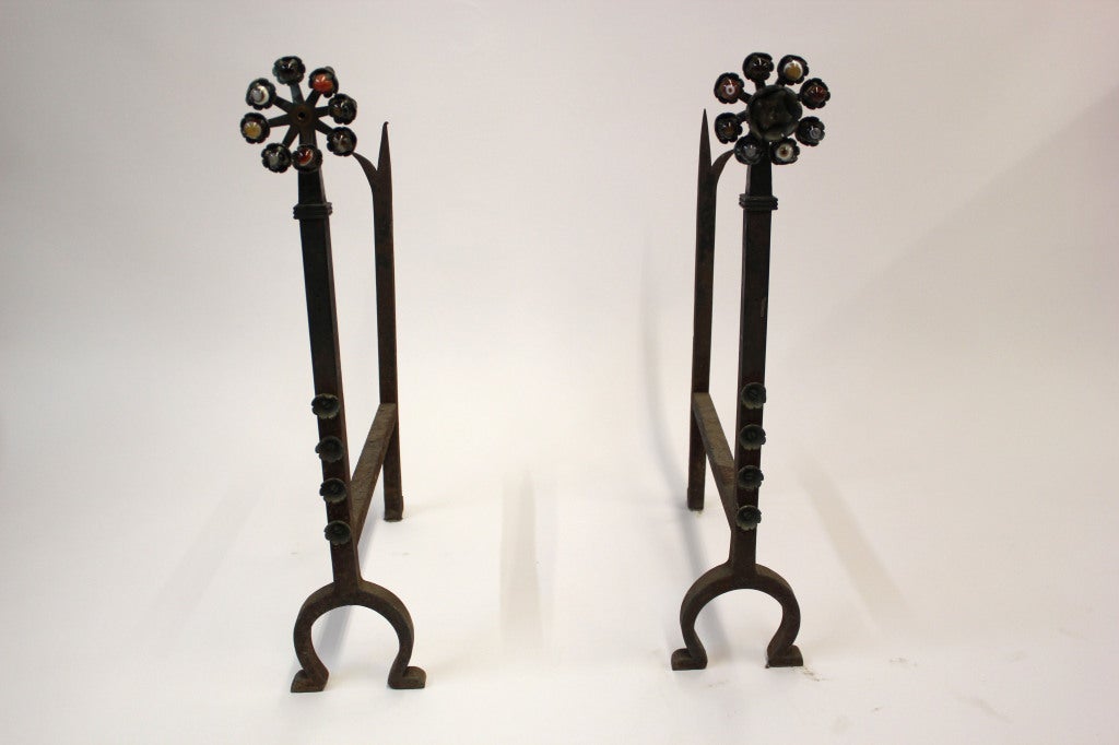 Set of iron andirons with horse shoe shaped base and Folk Art style detailing.

Not available for sale or to ship in the state of California.