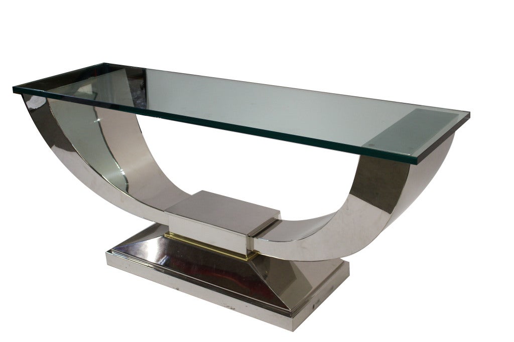 Art Deco U shaped console table. Polished stainless steal base with thick glass top. Thin brass accent plate in base.