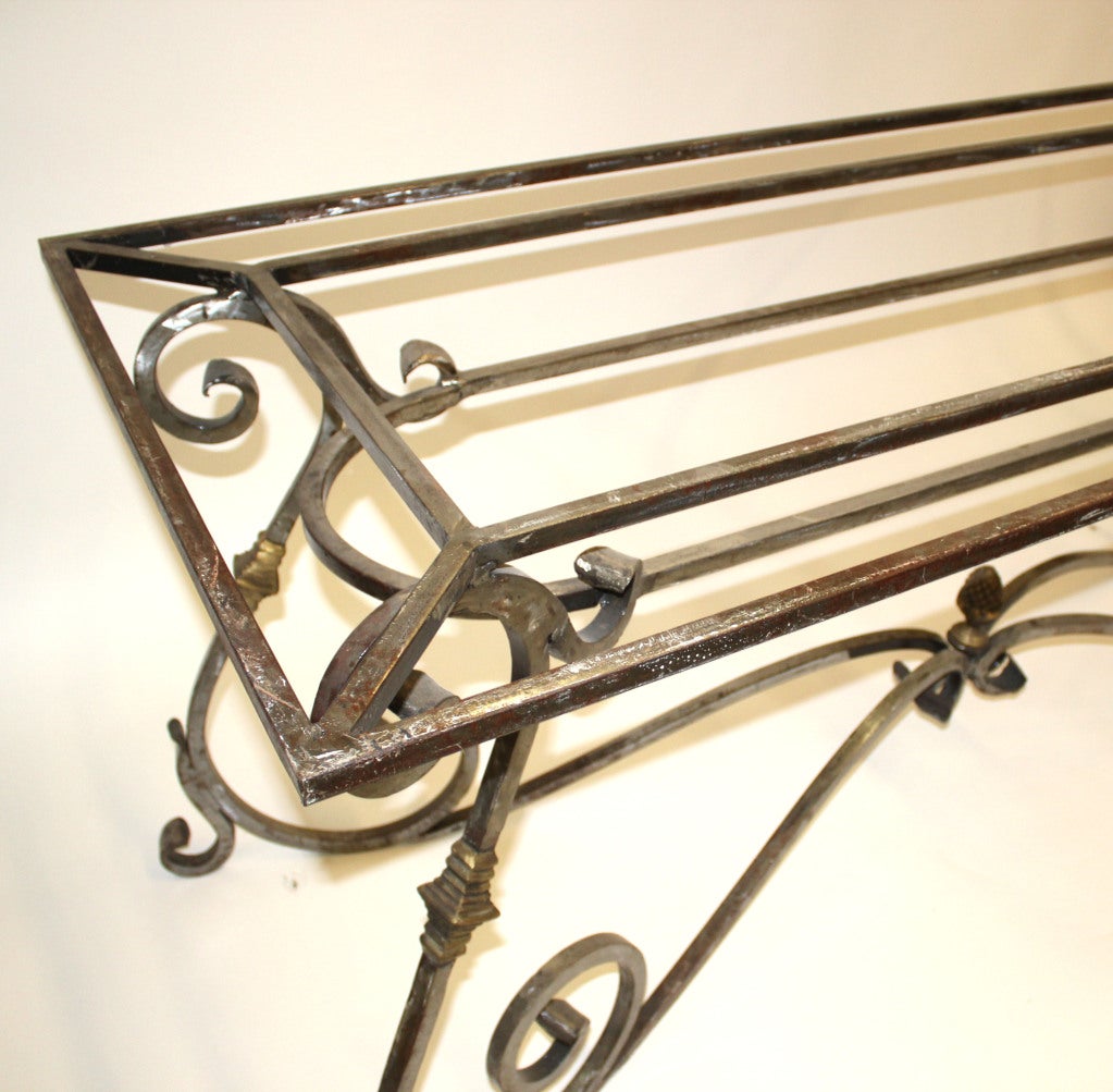 French wrought iron table base with four ornate over-scale scroll legs. Brass detailing throughout.