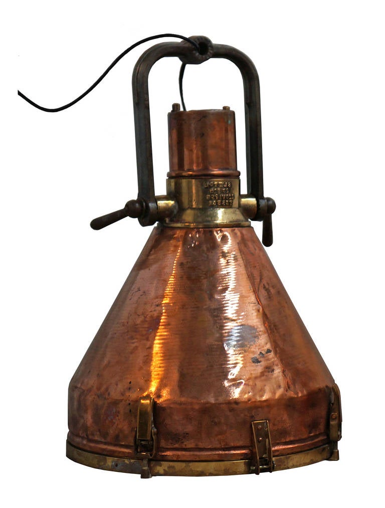 Set of six copper hanging lights with brass details. The body of all six are the same but two have a circular ring on the top of the iron arm. The head of one light needs to be refastened (See Image 8).

*Not available for sale or to ship in the