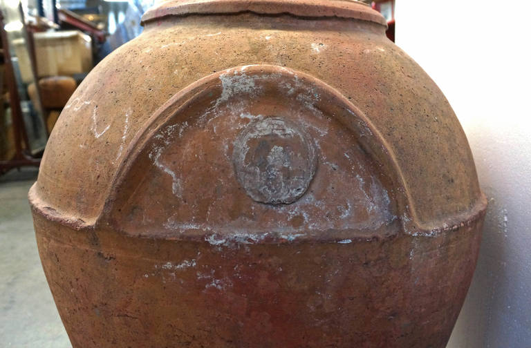 Gorgeous terracotta urn with what appears to be saltwater stains along the sides. Disc on the sides reads 
