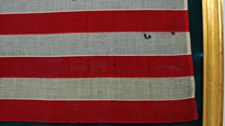 Original 45 star American flag in an unusually small yet desirable scale. The canton and stripes of the flag are made of wool bunting that has been pieced by machine. The stars are made of cotton and double-appliqued with a zigzag machine