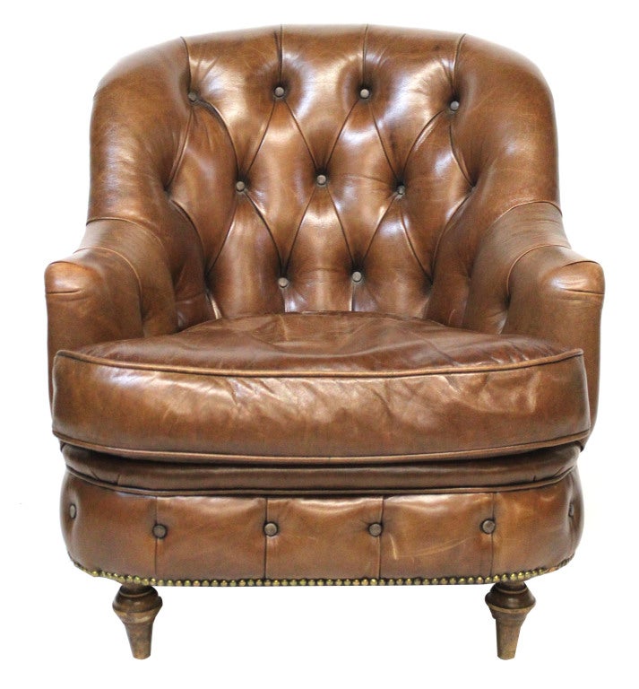 Classic English brown leather tufted club chair with nailhead detail throughout.