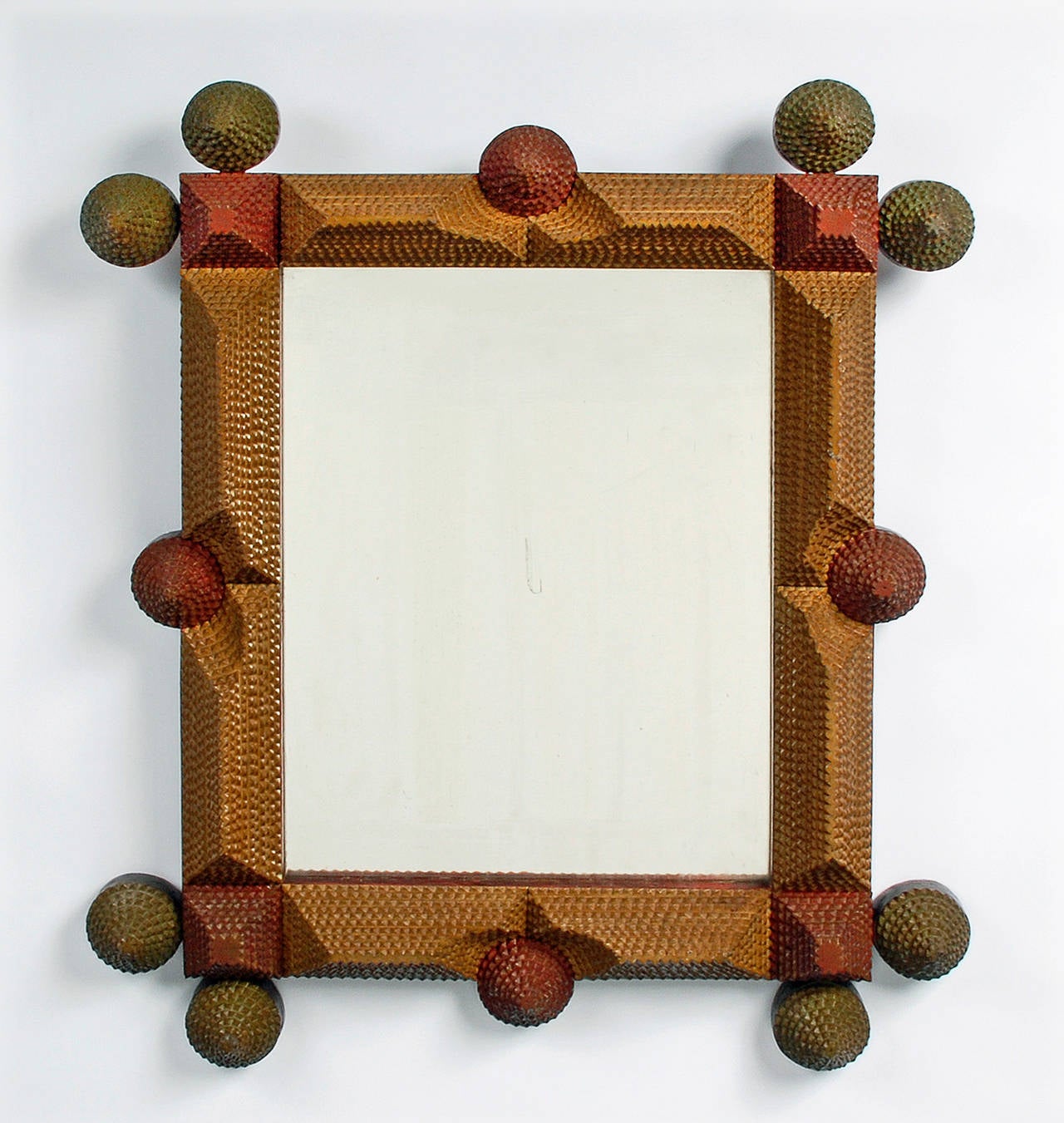 A whimsical Tramp Art mirror with an original three color painted surface. With playful rosette extensions, circa 1910.