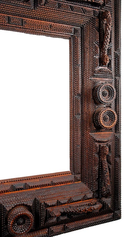 Masterpiece deeply layered tramp art frame embellished with carved handles and extended rounds. Expressive and well made this frame stands as one of the best examples found to date.