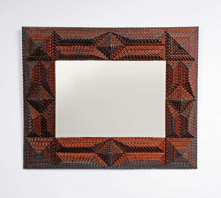 Tramp art mirror with deeply layered pyramidal embellishments.