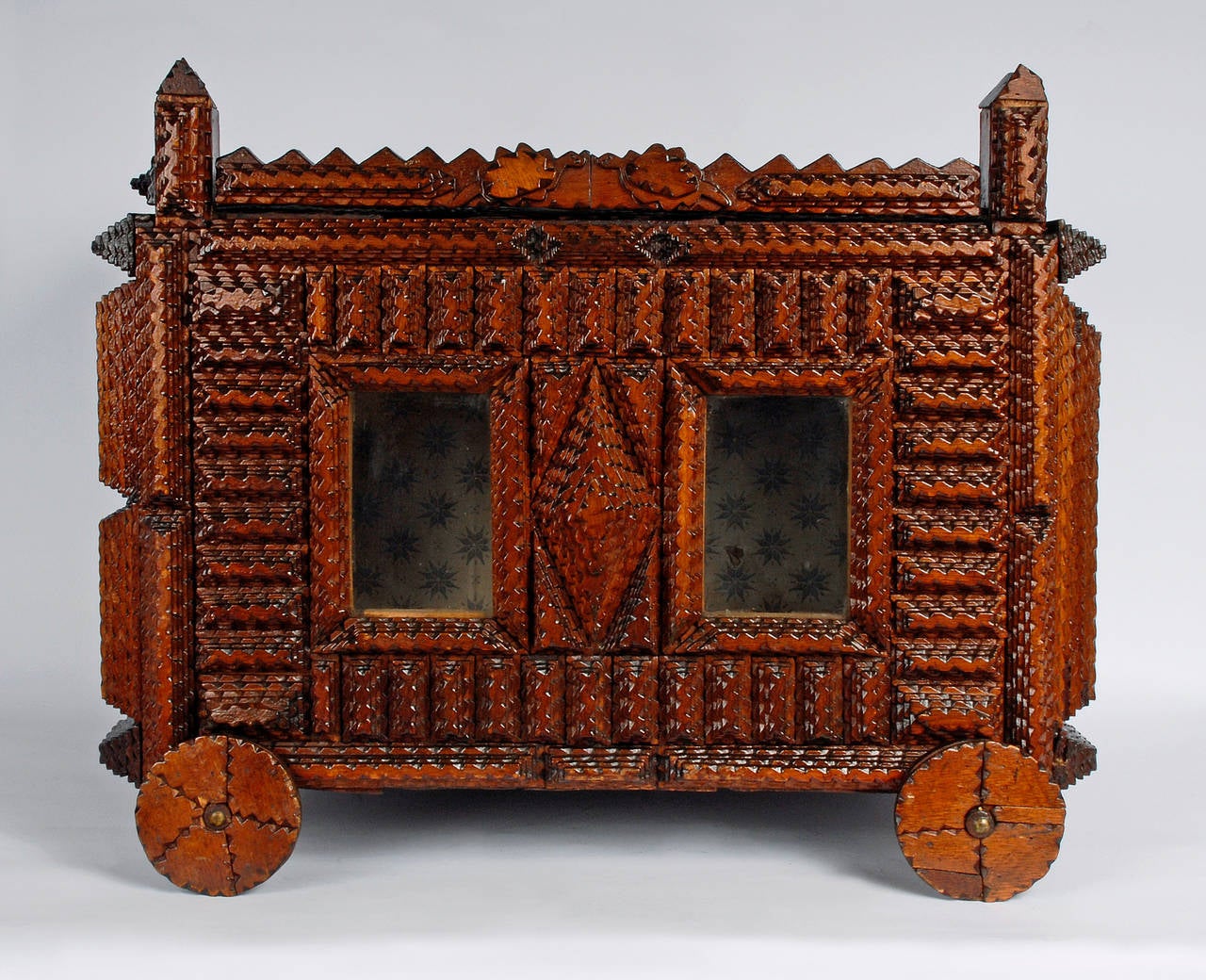 A whimsical tramp art circus wagon. One of the most unusual offerings we have had. The wagon sits on wheels which turn, there are doors on the front and back, and windows on one side. There are a pair of carved turtles with tails and beaded eyes
