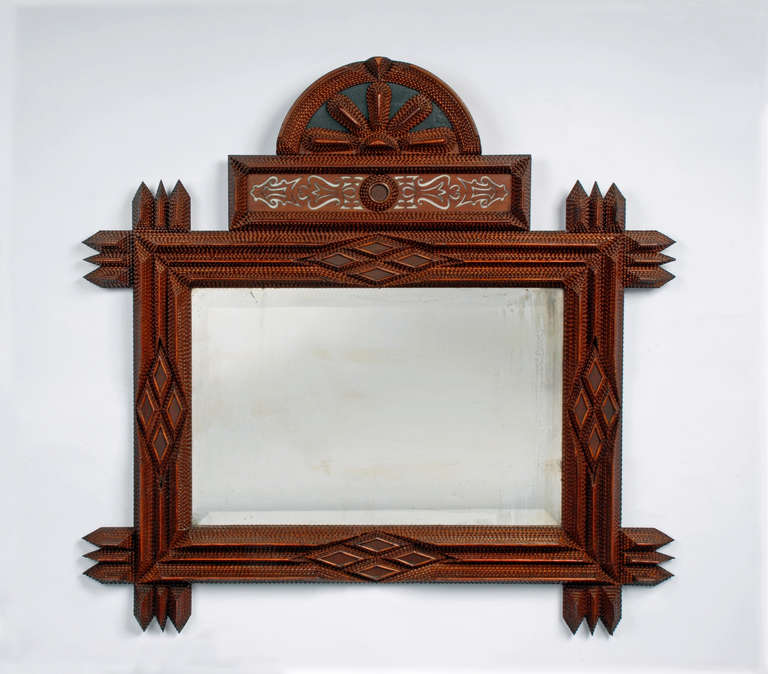 Fine tramp art mirror with a house shaped shelf. The mirror is large with an arched top and a cut-out element. The corners are extended. The companion shelf is house shaped with a draw having a large brass lion's head pull and inset mirrors. Circa