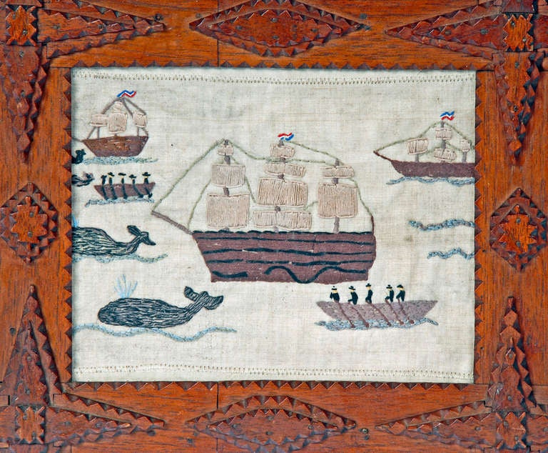 Wonderful colorful sampler depicting sailors on skiffs or row boats engaged in a pursuit of whales. There are several sailing ships in the sea and whales spouting water in this fine folk art textile mounted in a tramp art frame with pointed corners.