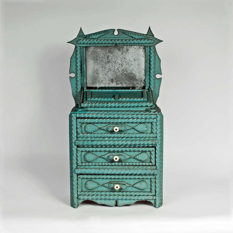 Blue painted miniature chest of drawers with a mirror, three drawers and a lift-up storage well. The drawers are decorated with tear drop shapes and have their original porcelain pulls. The painted surface is original and has nice crazing. Found in