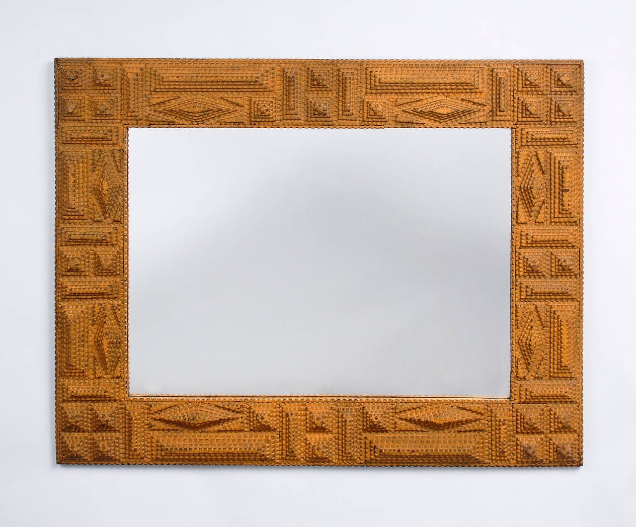 A fine painted tramp art mirror frame embellished with diamond, rectangular and square shapes. The frame is painted a muted mustard shade and is sturdy and well built. Illustrated in 'A Legacy in Tramp Art' on page 114.

Circa 1910 - 1920