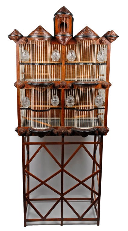 Monumental finely detailed tramp art bird cage in the shape of a house on its original stand.  The bird cage is in one piece & it can be displayed seperately without the stand.  Very rare form this superbly executed bird cage has four bottom