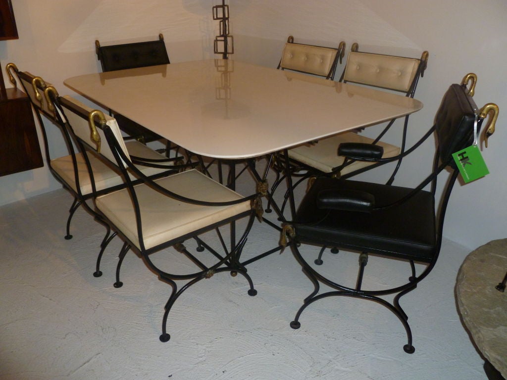 A truly gorgeous set.  Six chairs, two Captains chairs and four side chairs, surround a wonderful iron and brass table with milk glass top.  The table is decorated with brass balls at the feet and four faces around the base of the table.  The chairs