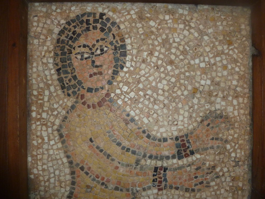 An incredible find!  A Roman mosaic of a nude woman with arm cuffs and a necklace.  Perhaps she is dancing.  The mosaic is preserved professionally with a plaster backing and wooden frame.  It comes with a metal stand.  The size of the mosaic is 27
