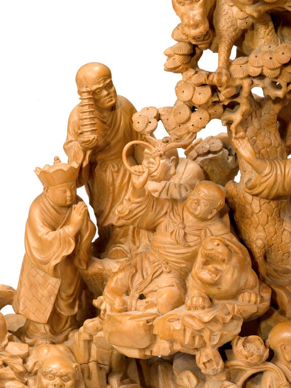 Dating to the Early Republic Period (1911 - 1949) this seemingly single section boxwood figural group is carved to show eighteen immortals amongst mythical beasts in a bamboo grove.  Presented on a dark coffee hue root stand, this impressive carving