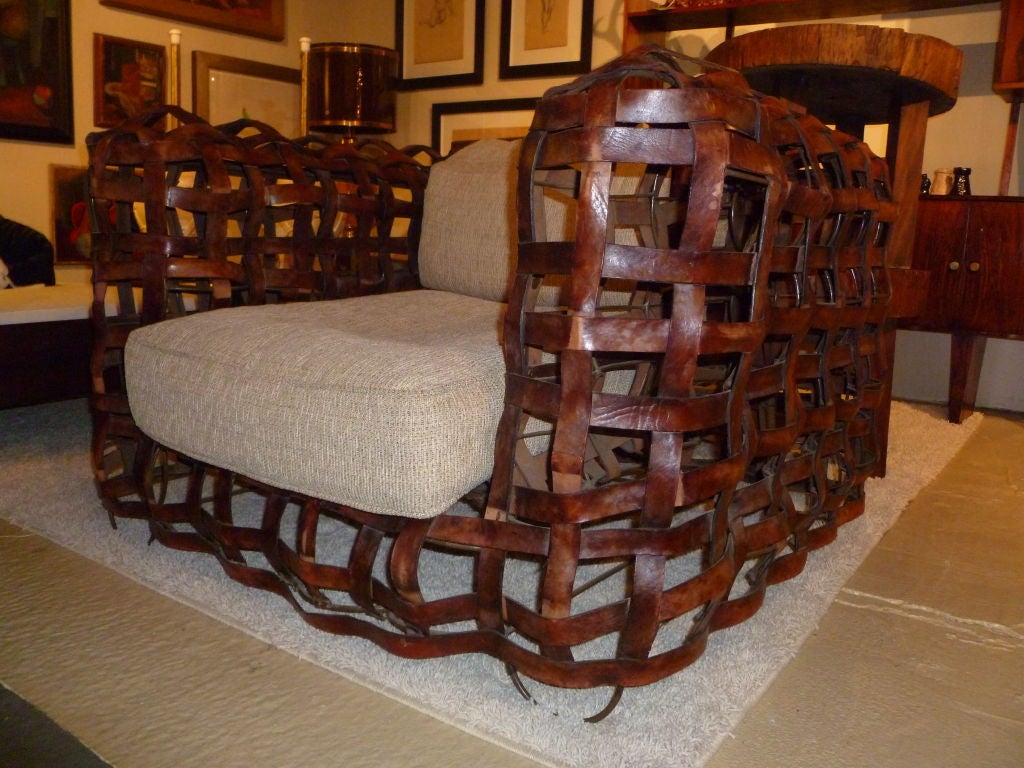 This is an absolutely incredible club or lounge chair.  With a wrought iron frame covered with leather straps, this is truly amazing.  The wrought iron frame forms the shape of the club chair, while the brown leather straps (with their gorgeous