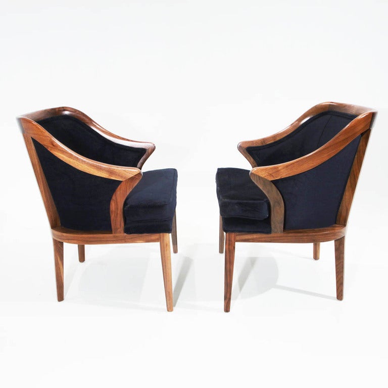 A pair of (or up to the 6 available) sophisticated Harry Lunstead walnut and dark navy mohair side chairs. They have sculptural backs implying the beginning of an armrest shape and have been newly refinished and reupholstered. Measures: Seat depth