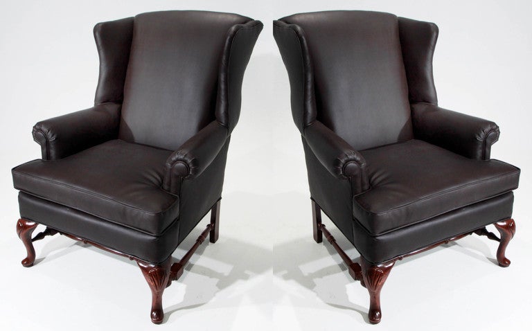 A pair of armchairs that have been upholstered in dark brown high quality Lorica or pleather.  The foam has been replaced completely as well as the joot strapping on the interior frames. The sculptural bases have a rich walnut finish. Seat depth