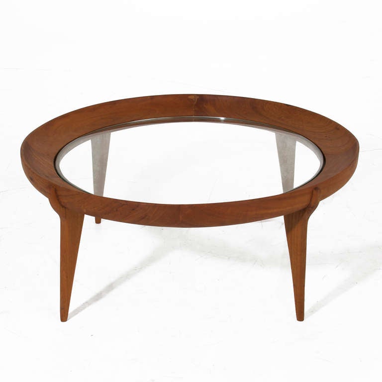 A round solid Caviuna coffee table with sculptural legs and an inset glass top designed by Brazil's Giuseppi Scapinelli. The finish is a durable water-resistent oil finish that feels like butter and protects the Brazilian hardwood. 

Many pieces