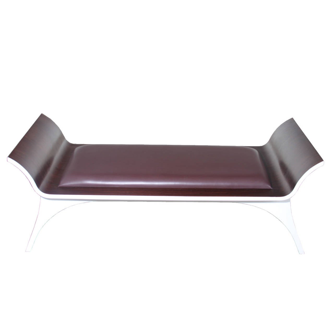 An elegant rosewood bench from Brazil. The seat is upholstered in a burgundy leather complimenting the red tones of the rosewood. The underside of the bench has been painted white adding contrast to the sculptural design with curvaceous
